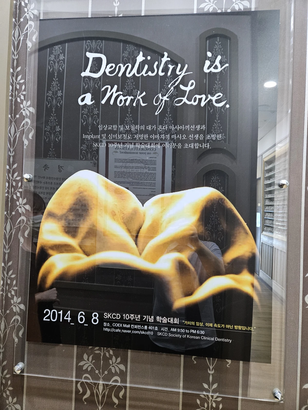 금빛 치아의 교합면과 Dentistry is a Work of Love 문구가 담긴 SKCD 학술대회 포스터